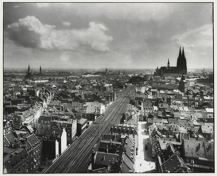 Black and white photo by August Sander. Looking down on Cologne from above. The cathedral can be spotted in the background.