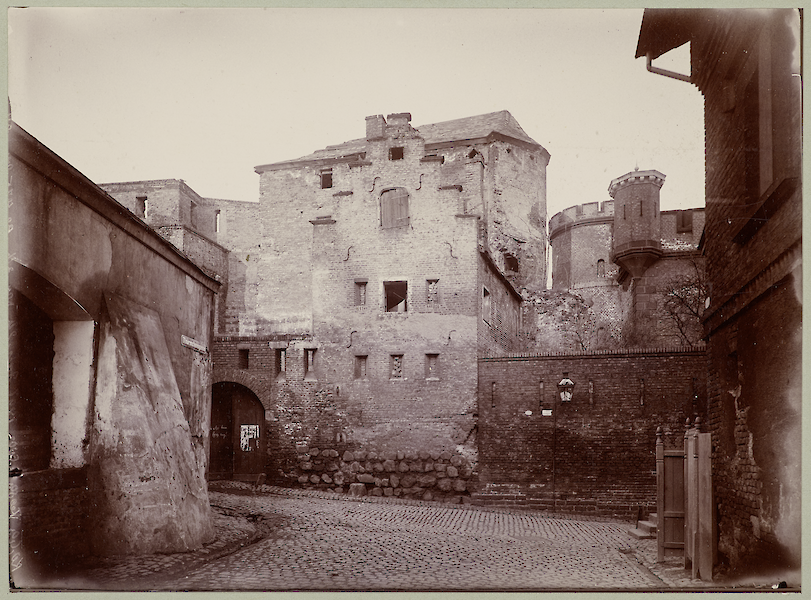 Discolored black and white photo. You can see an empty alley, the Kunibertstorburg